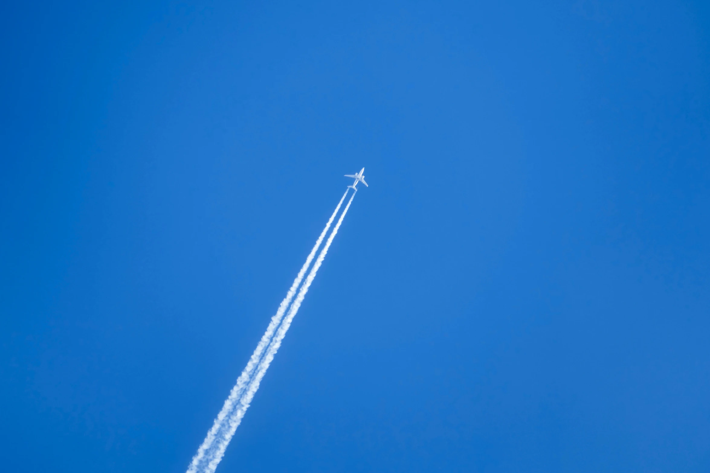 a jet flying in the sky leaving a contrail