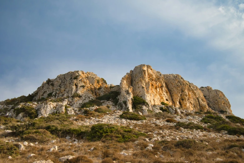 a large rocky cliff face on a clear day