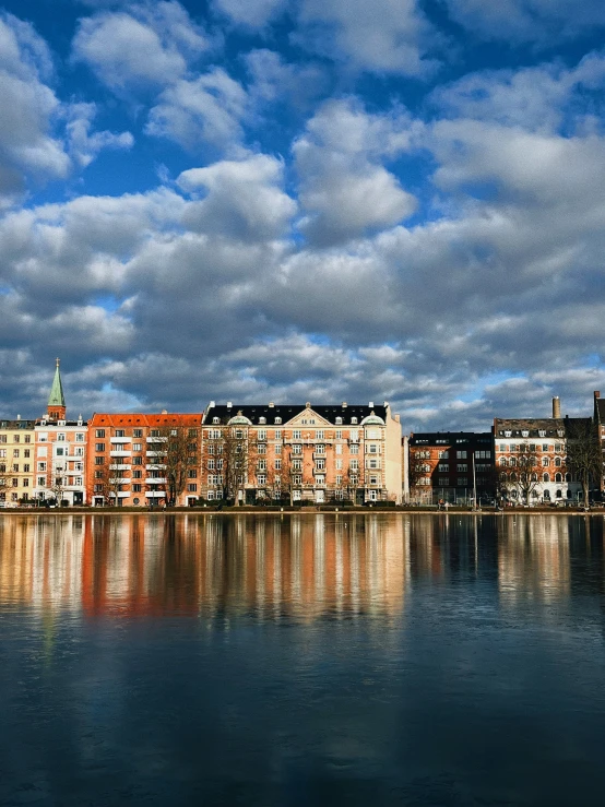 a river with large buildings and cloudy sky