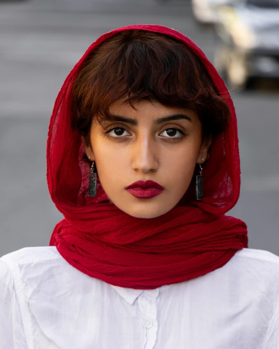 a close up of a person wearing a white shirt and a red scarf