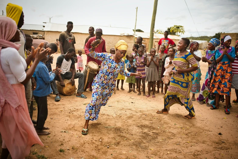 a woman dancing in front of people in native dress