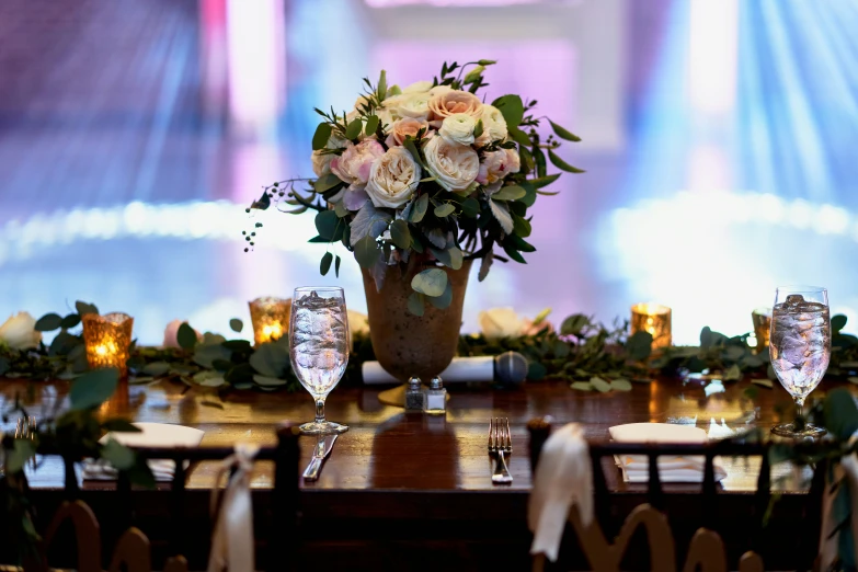 vases are placed on tables in front of a large screen