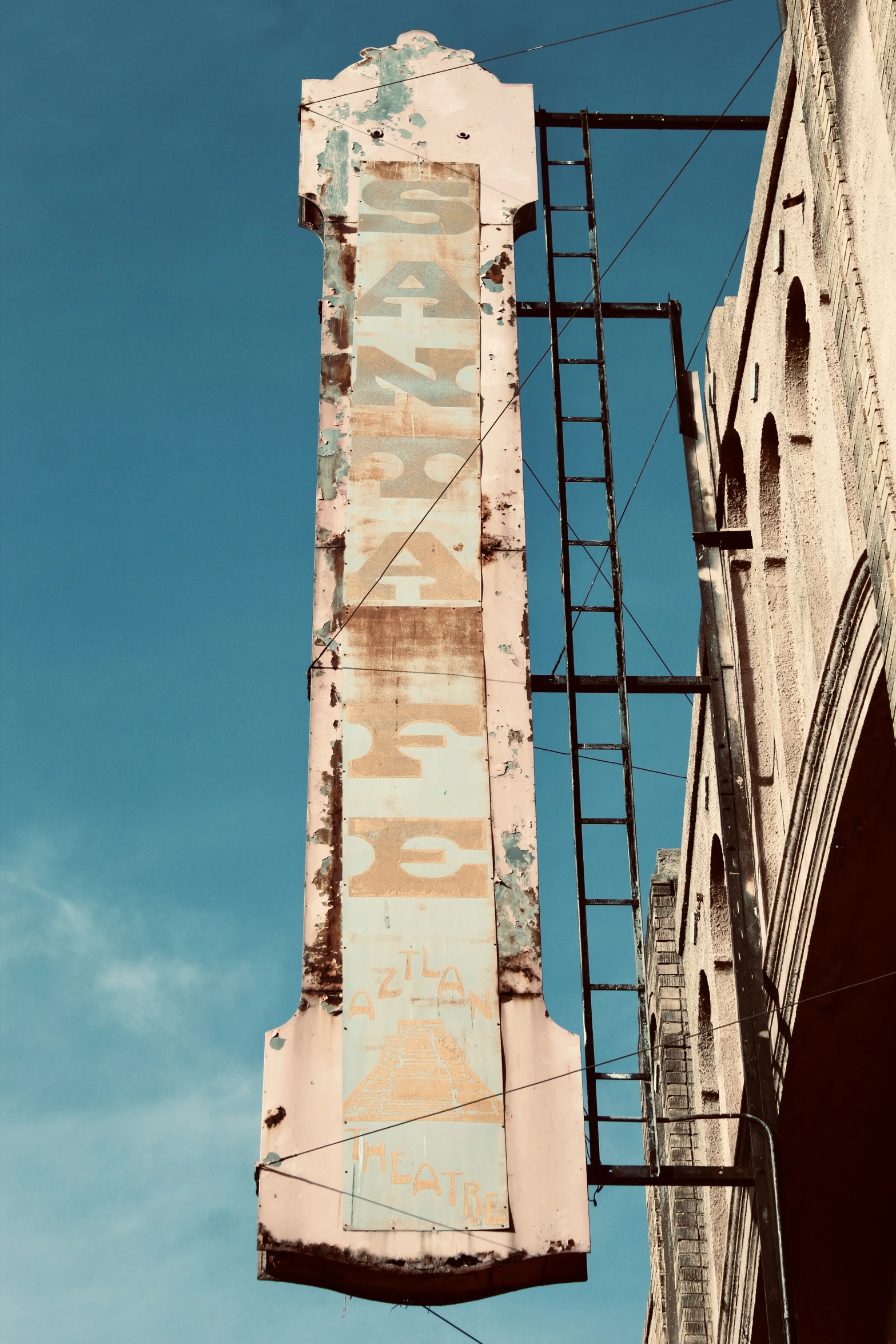 a rusty old sign is against the sky