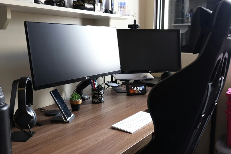 a wooden desk with two computer screens on it