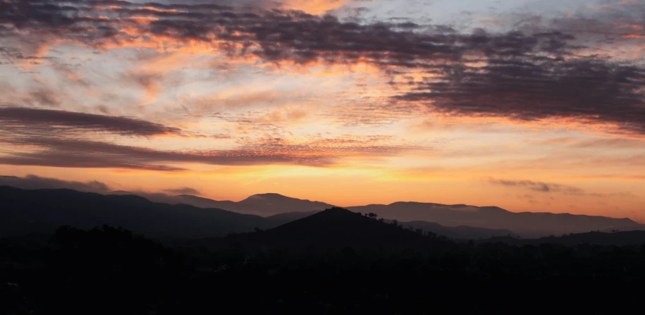 the sunset in the valley below a mountain range