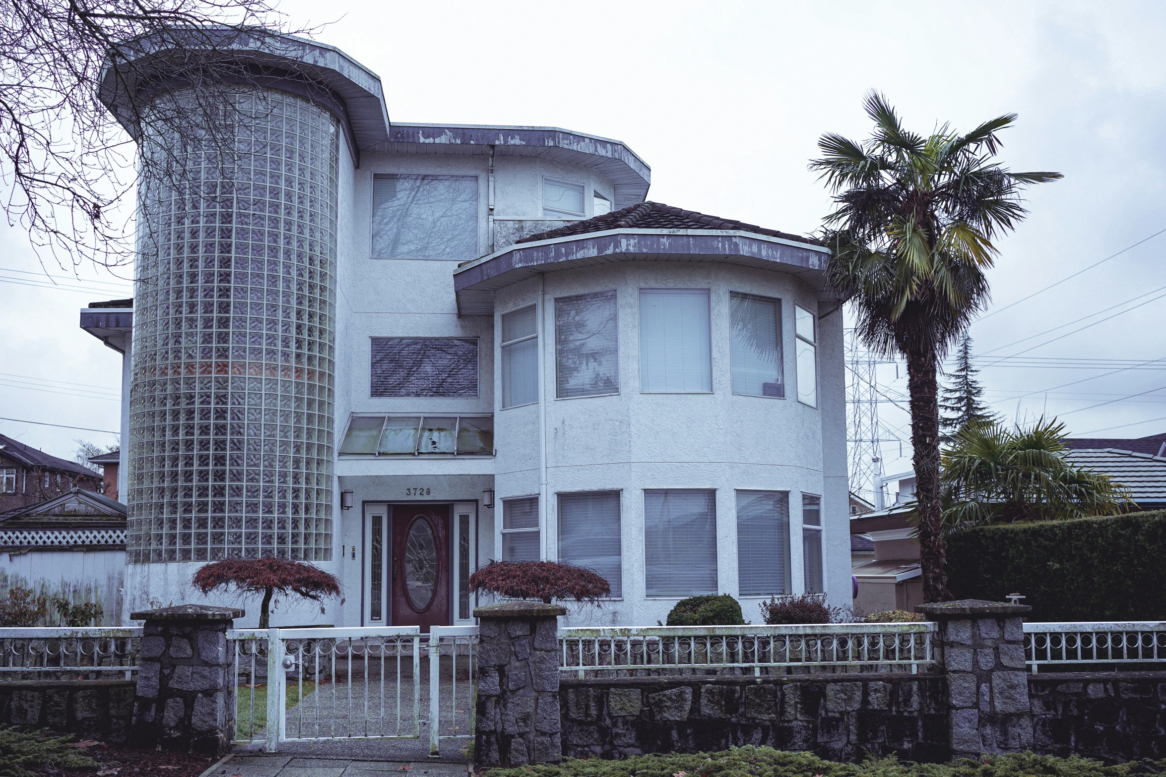 the front view of a white house with an arched window