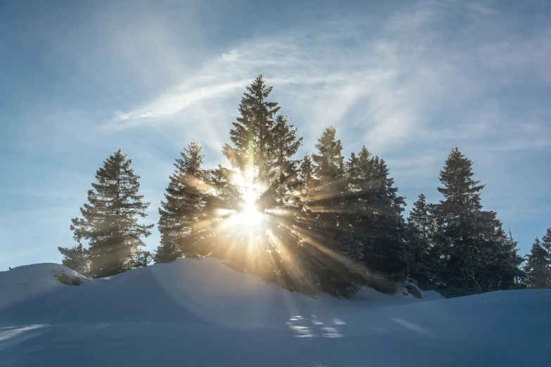 the sun peeks through the clouds in front of a snow - capped mountain