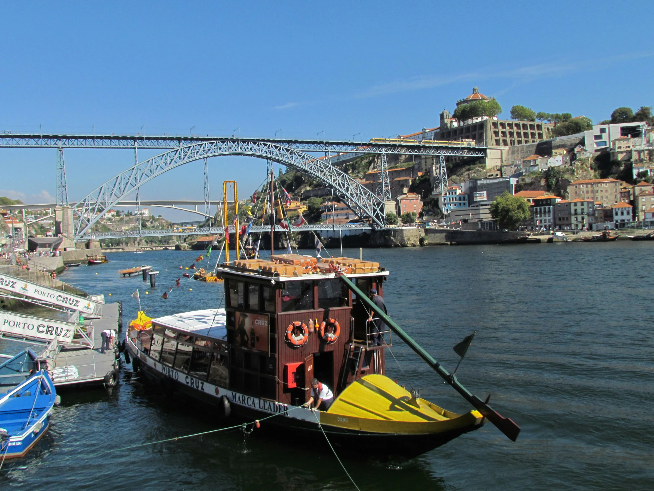 boats parked on the water under a metal bridge