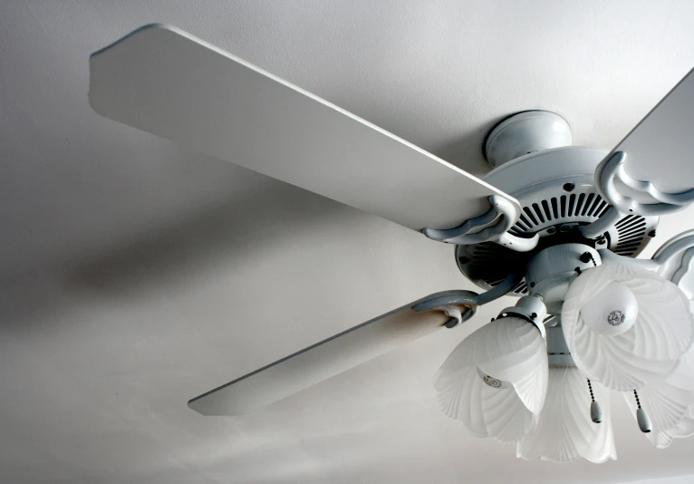 a close up po of a white ceiling fan