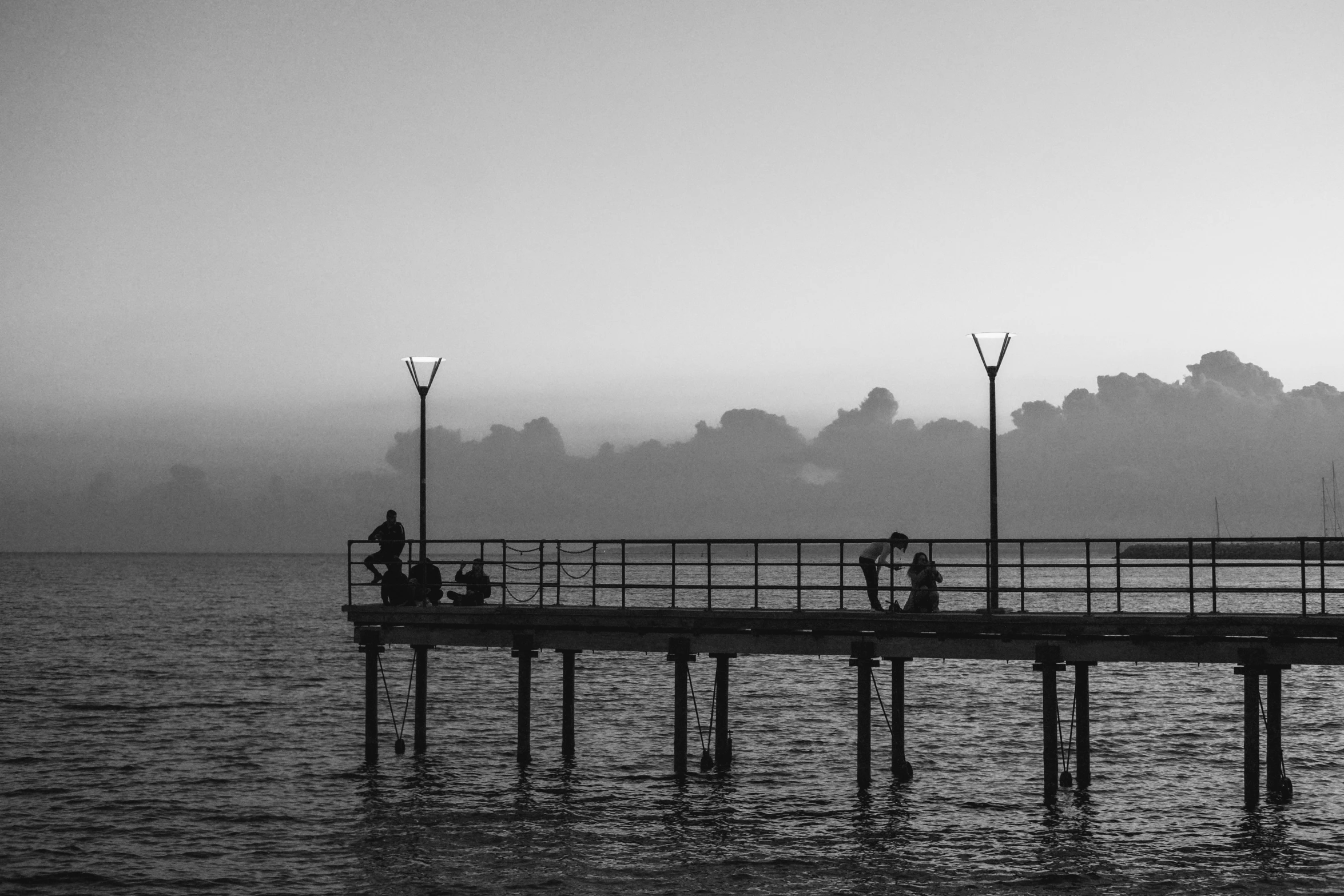 two people sitting on pier with their bikes