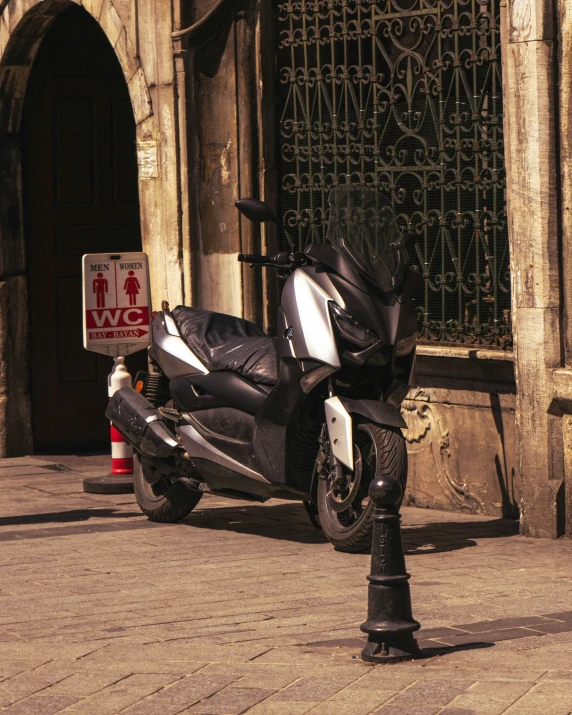 a motorcycle parked on the side of a brick street