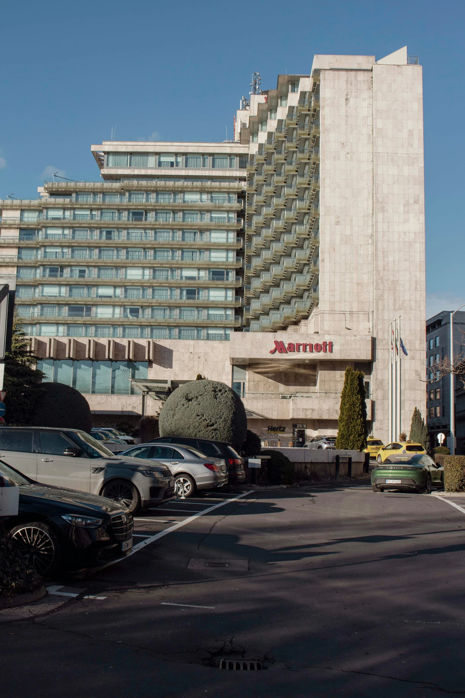 cars parked in a lot next to a large building