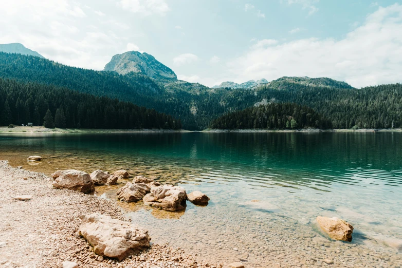 there are rocks on the shore of the lake