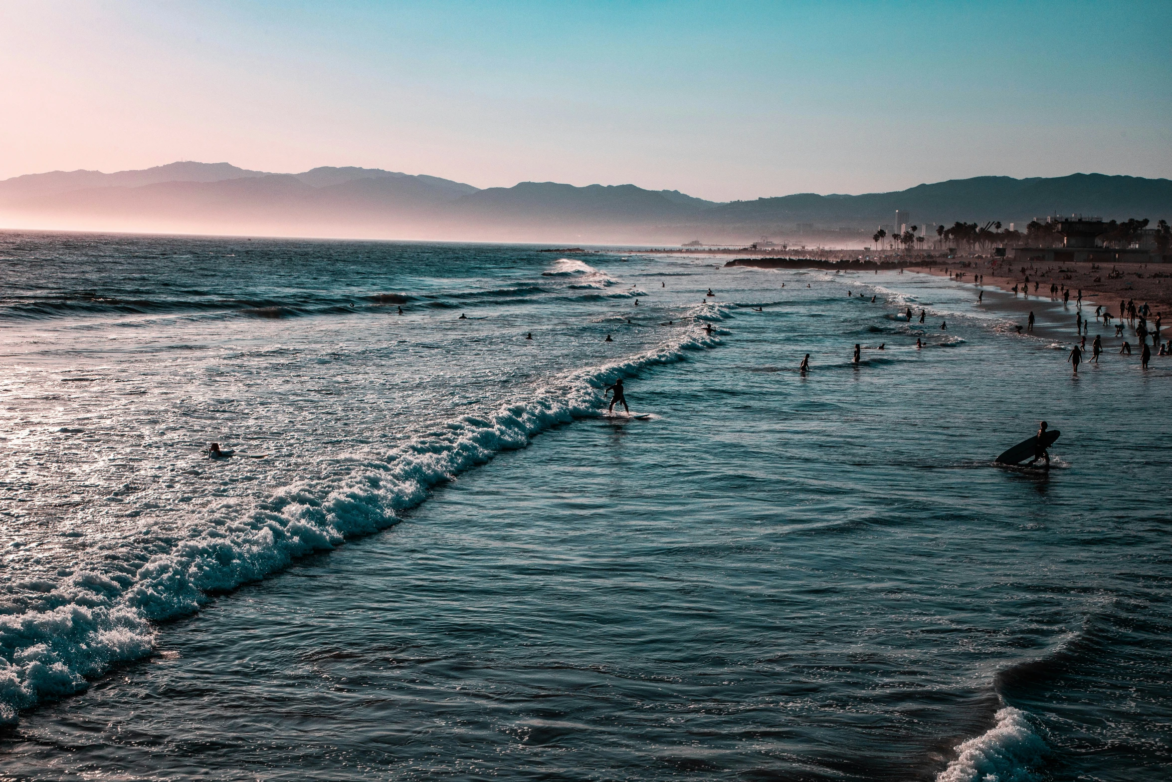 a couple of people riding surfboards on a body of water