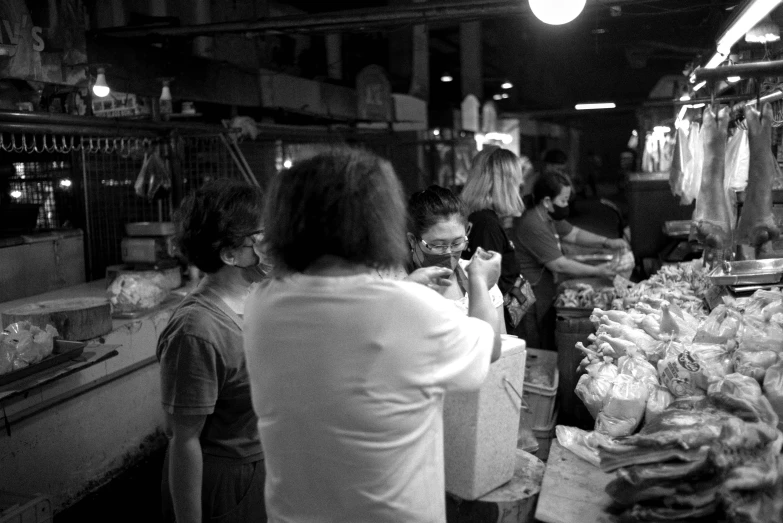 people shopping in a store filled with produce