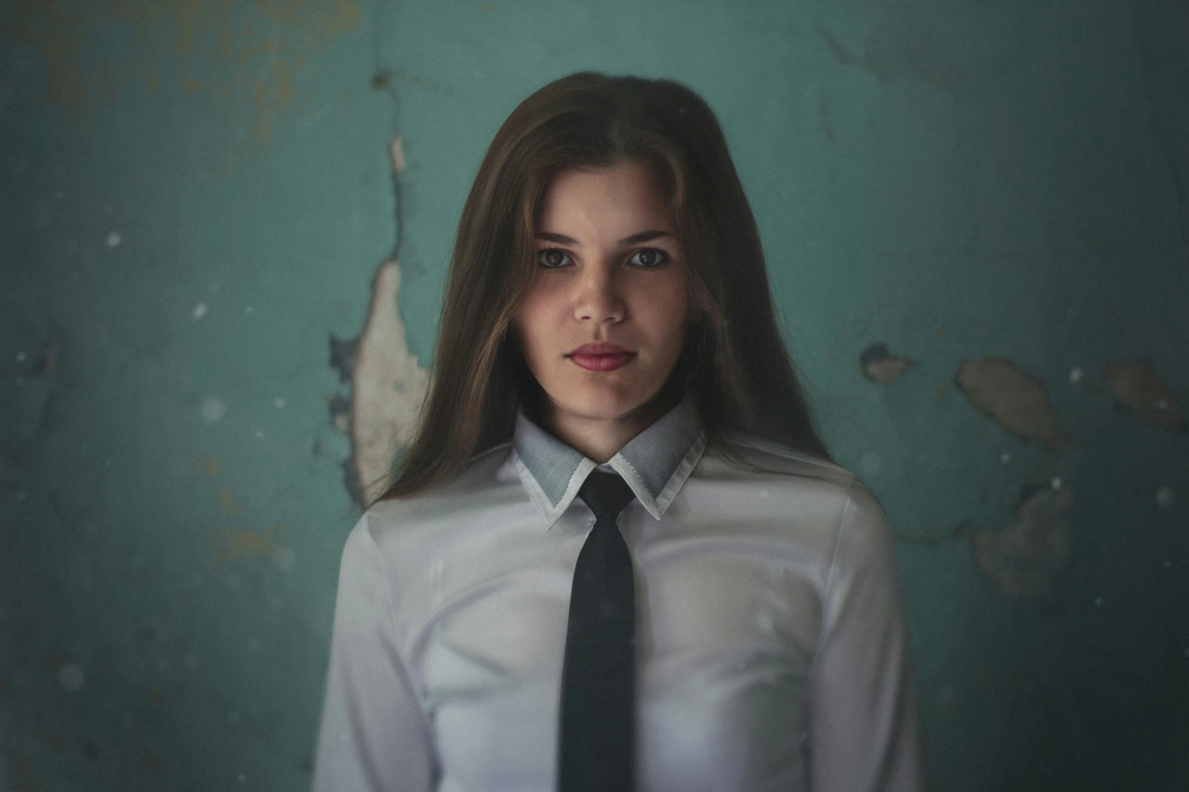 a woman is standing in a white dress shirt and black tie