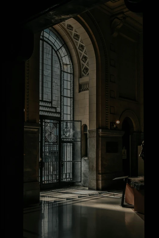 a dark room with a window and a large glass door