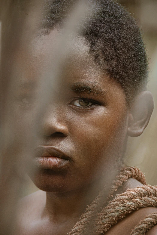 a child in the foreground with a bushy top is reflected in the glass