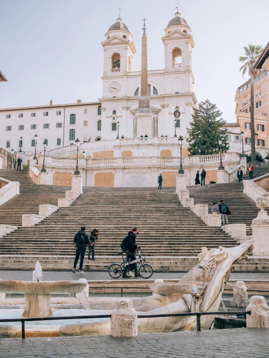 some people walking and sitting on steps in the street