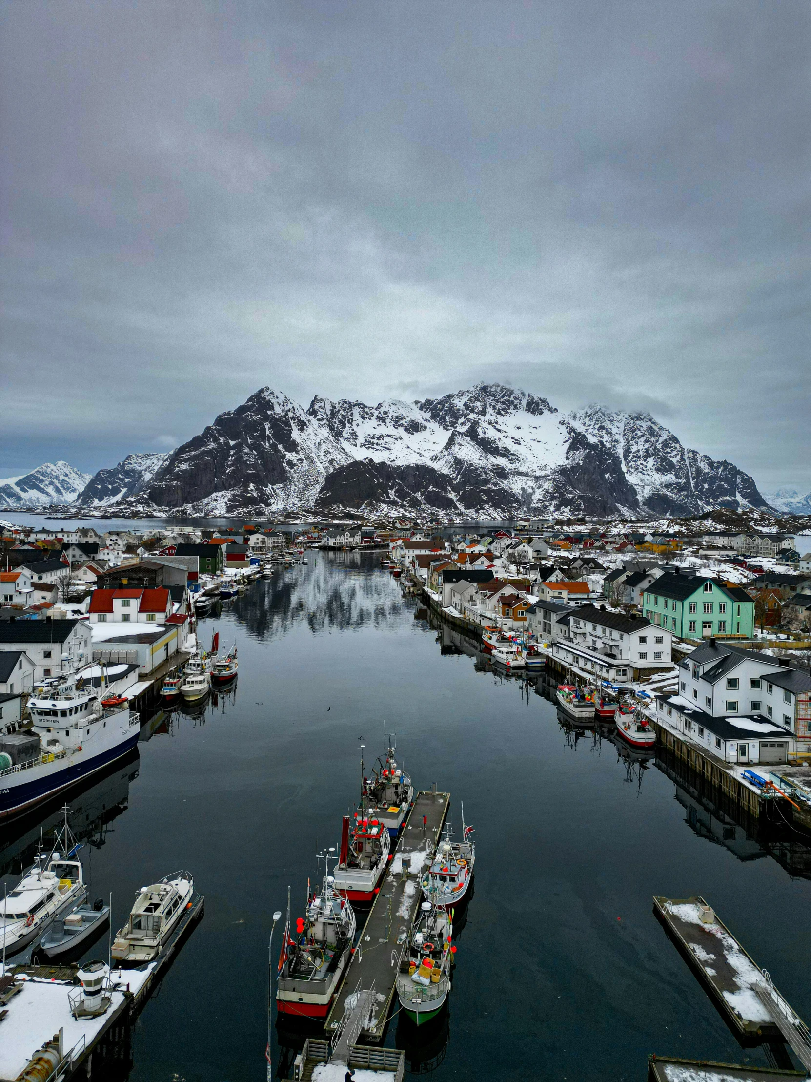 a snowy view of a harbor with many boats parked on it