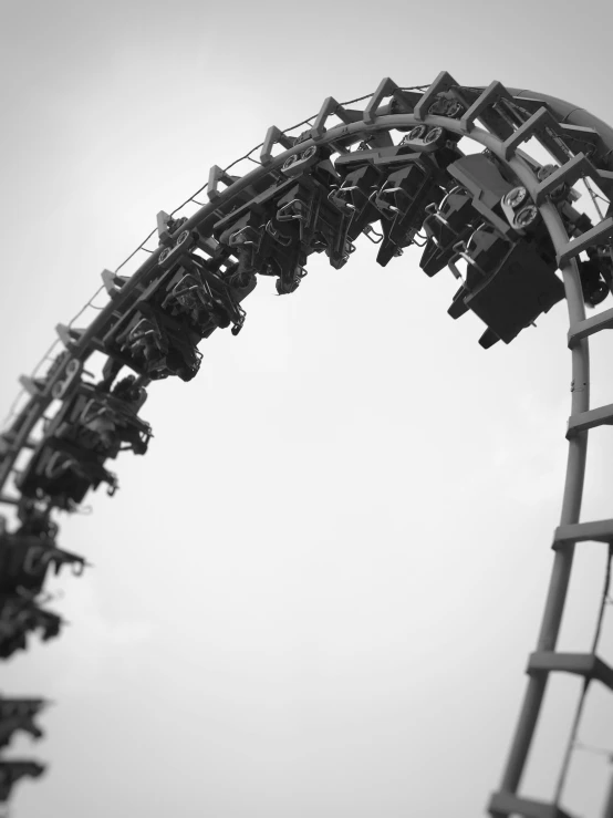 a roller coaster rides against a cloudy sky