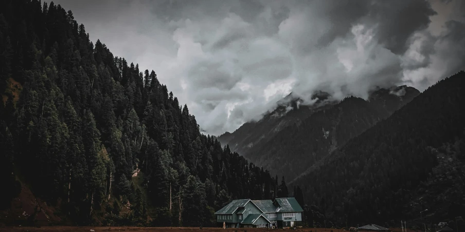 a house on a field with mountains in the background