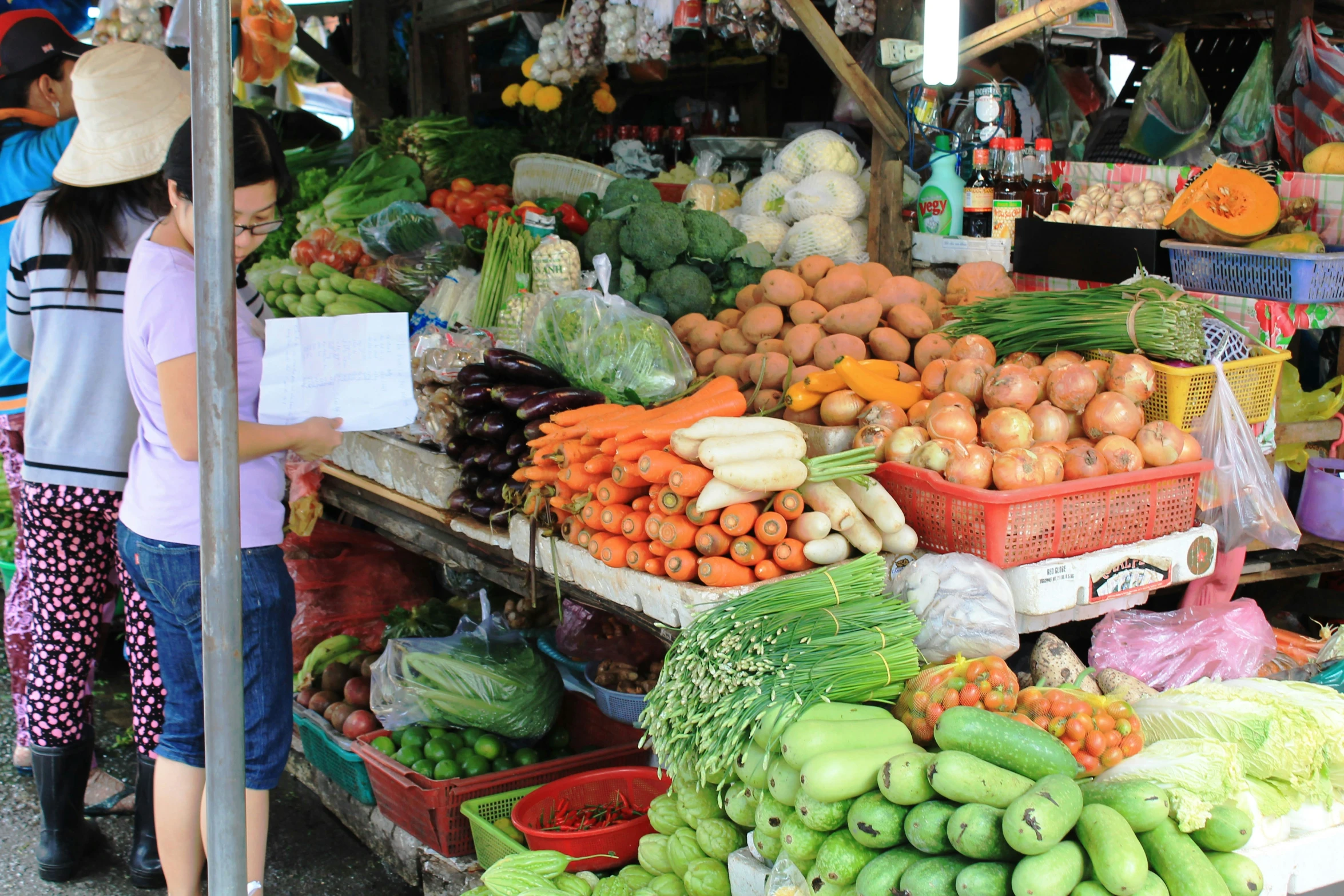 the group of people are shopping at the farmer's market