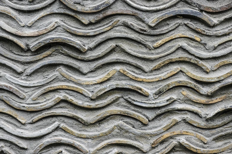 wavy pattern on stone wall with yellow and black stones