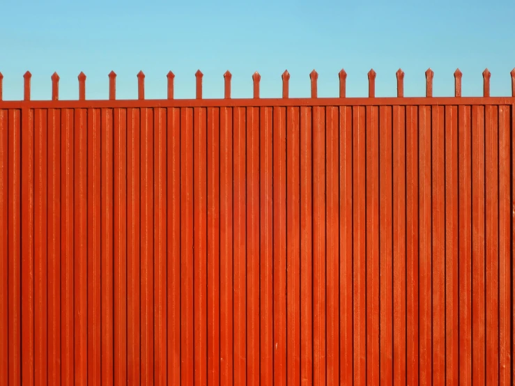 a tall red wall that is against the sky