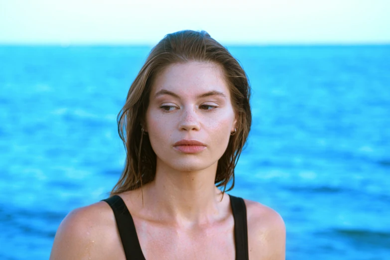 a woman stands on the water in front of the ocean