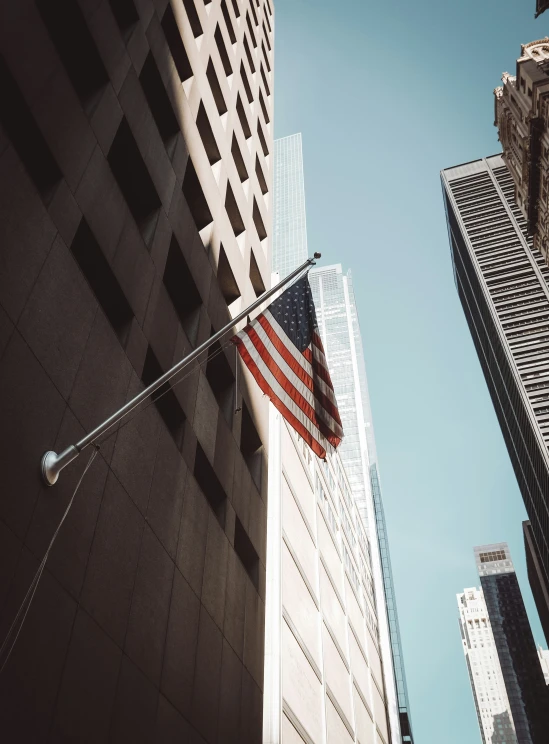 an american flag flies between two tall buildings