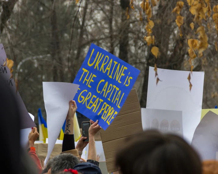 several people holding up signs in the air