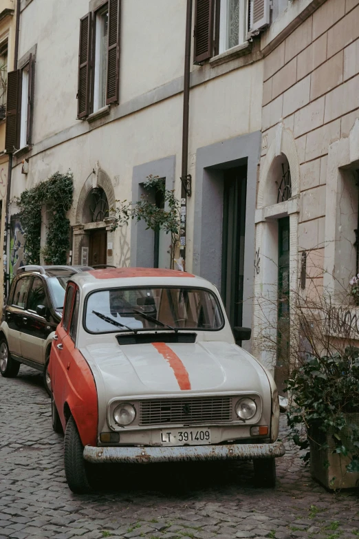 a parked car sitting next to a couple of cars