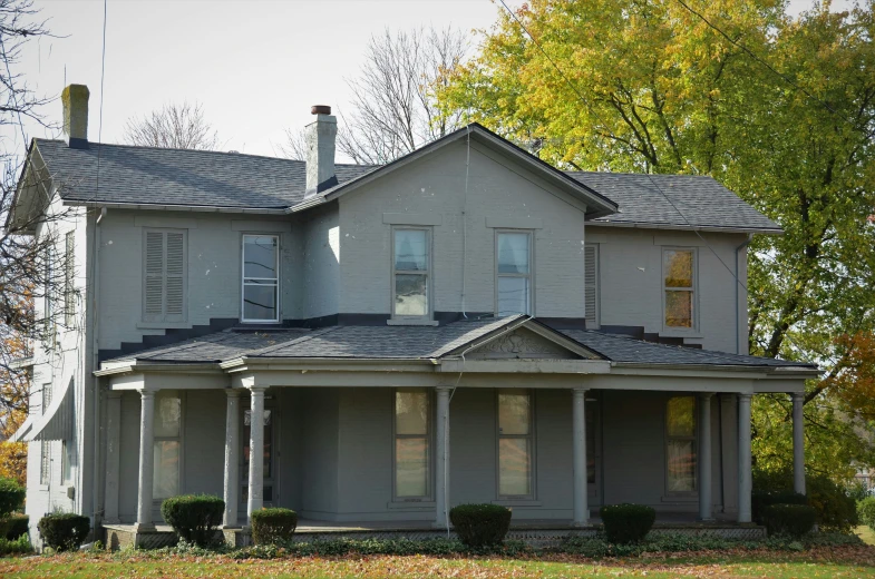 a grey house with a tree in front of it