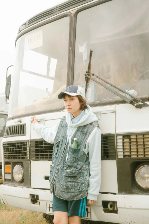 young woman posing for picture next to a bus