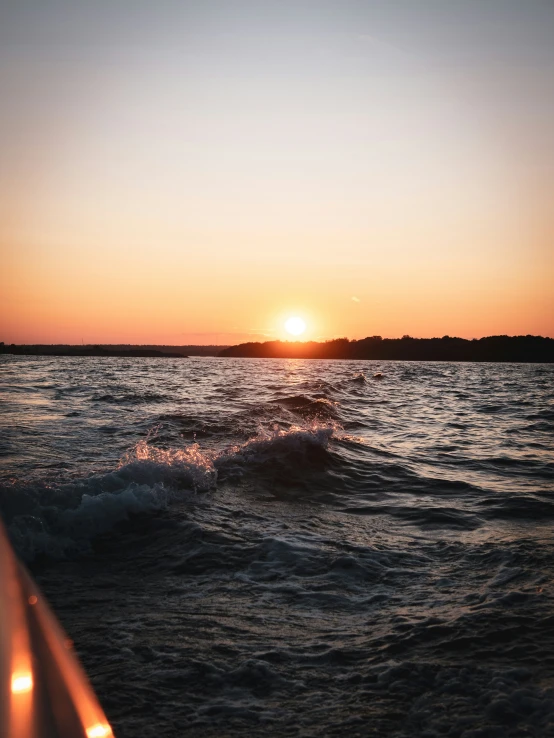 the sun is rising over the horizon as it rises over the ocean