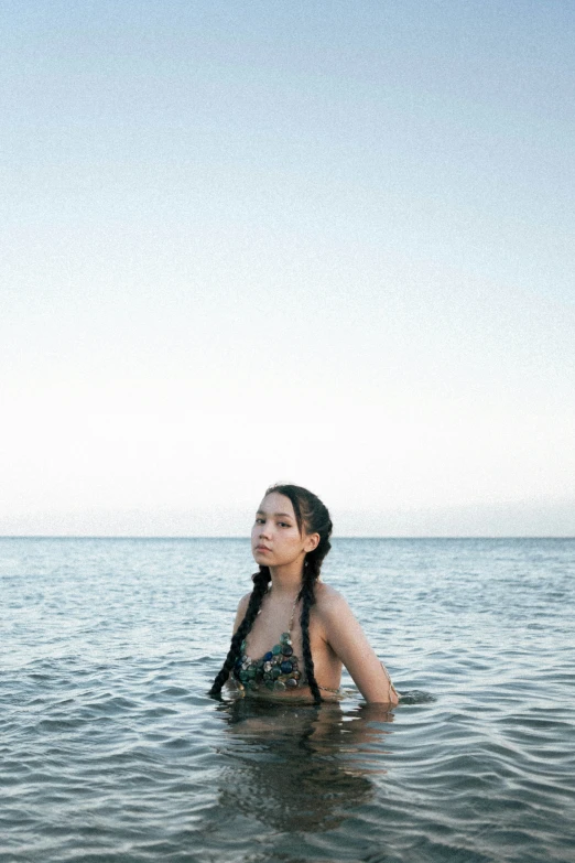 a woman with black hair sitting in the water