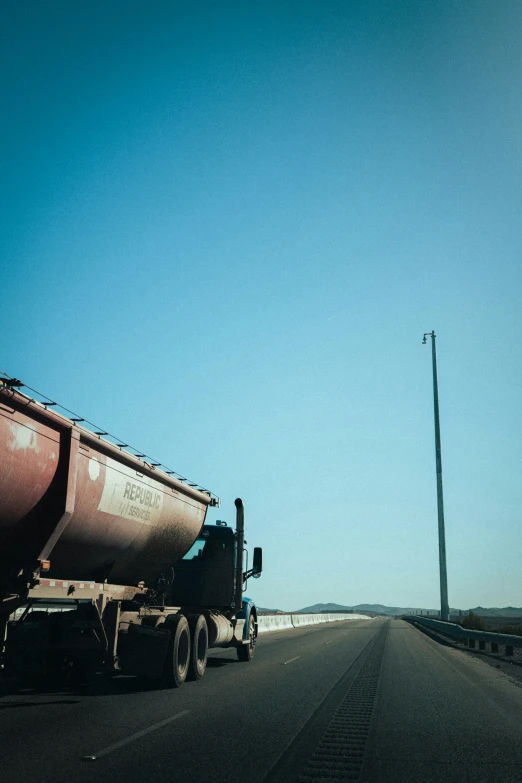 a big truck driving down a highway next to a pole