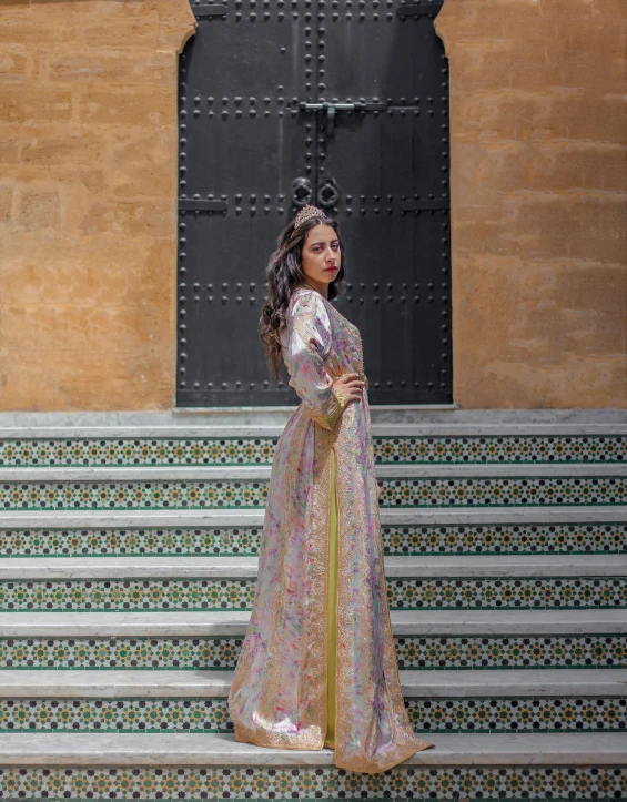 a woman poses on a very elaborate set of stairs