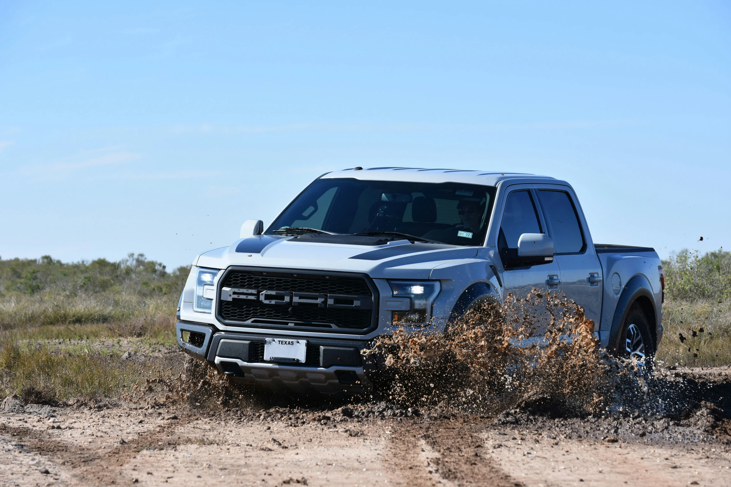 silver truck in a dirt field on a sunny day