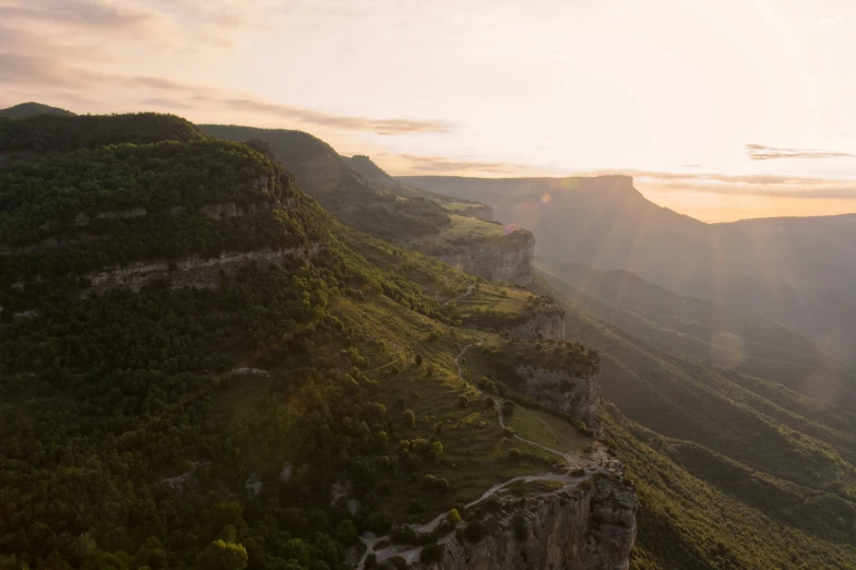 the sun setting over a rocky landscape in the mountains