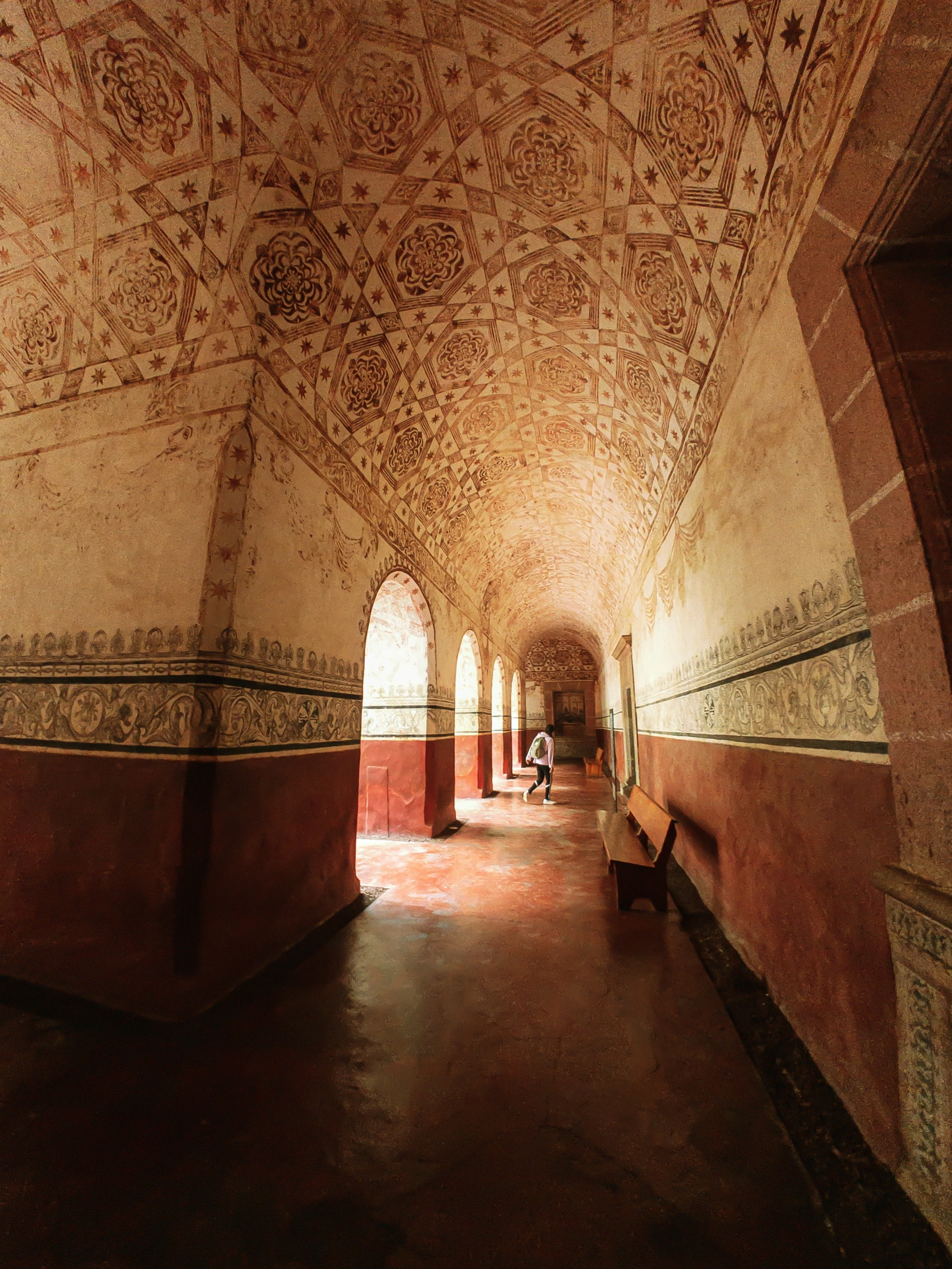 a large empty and colorful building with many patterns on the ceiling