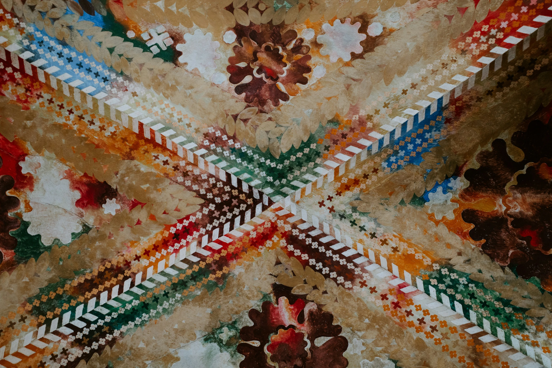 an artistic display of leaves, flowers and design on a piece of fabric