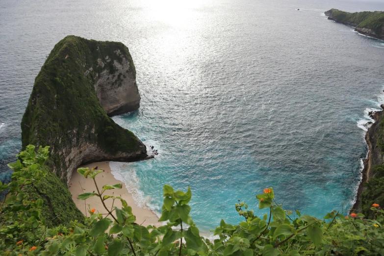 a view of a beach on a hill near a cliff with water