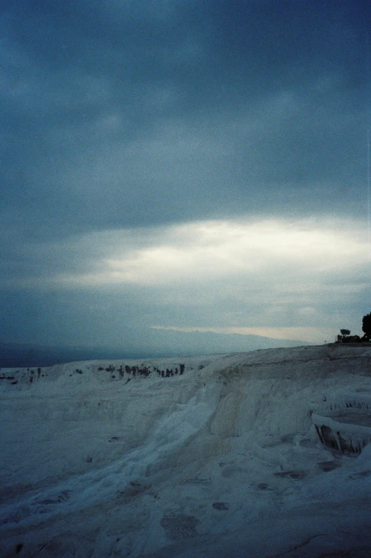 a snow covered road in the middle of a large body of water