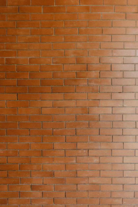 a red brick wall with an orange bench sitting in the corner