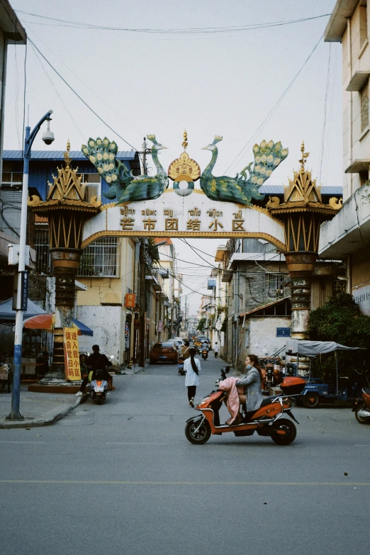 a person is riding a motorcycle by a dragon arch