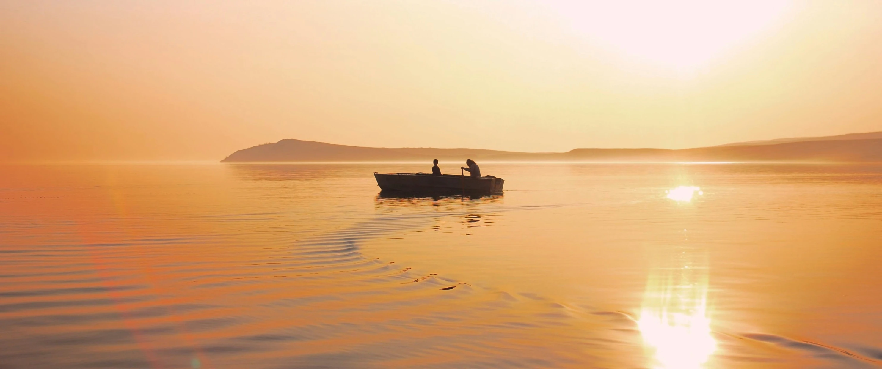 a pair of people on a small boat on calm water