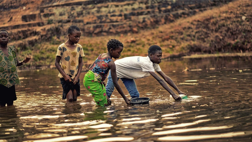 the four boys stand together in the water