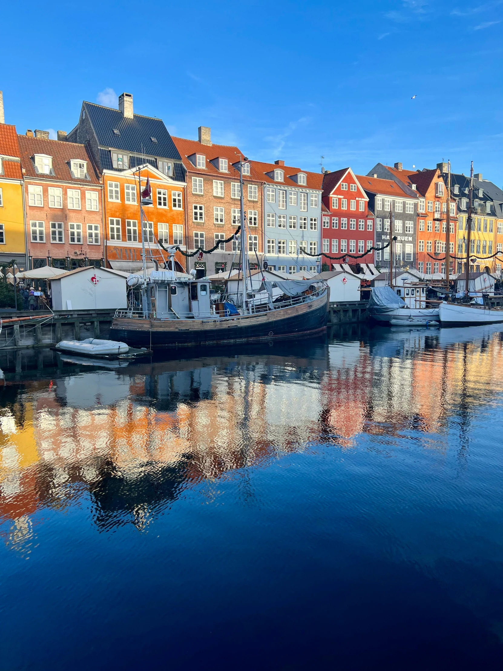 boats sitting in a harbor near some houses